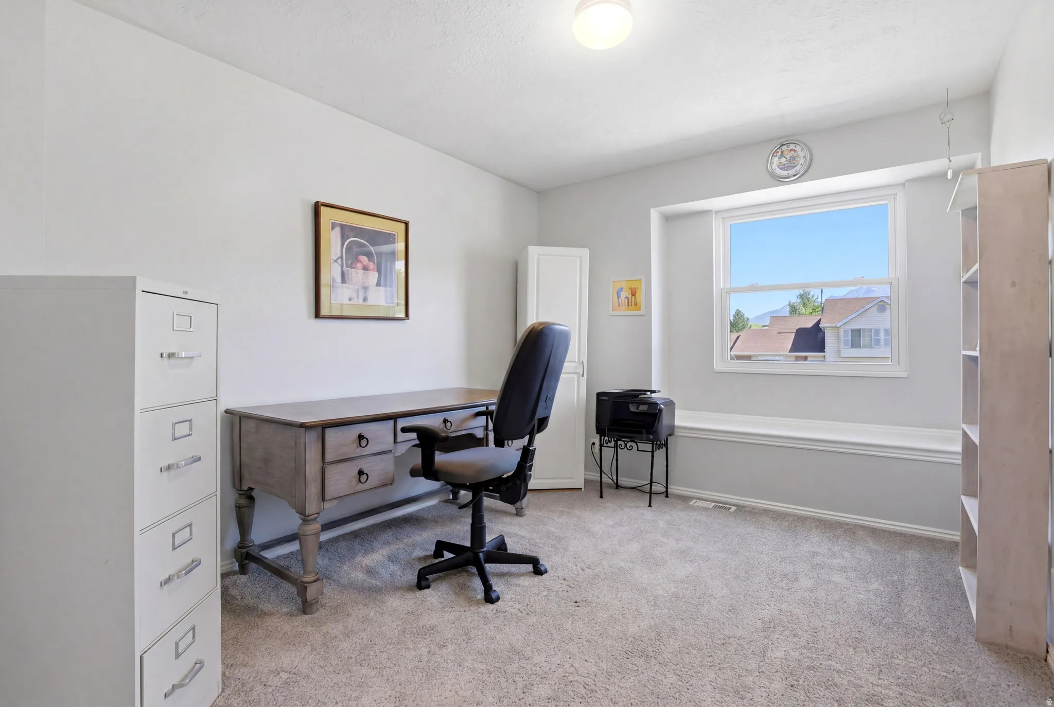 Spacious room with light-colored carpeting and a built-in window seat