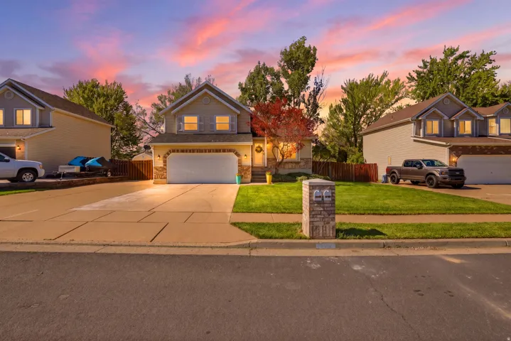 Two-story residence featuring a two-car garage, arched brick accents, and a large concrete driveway