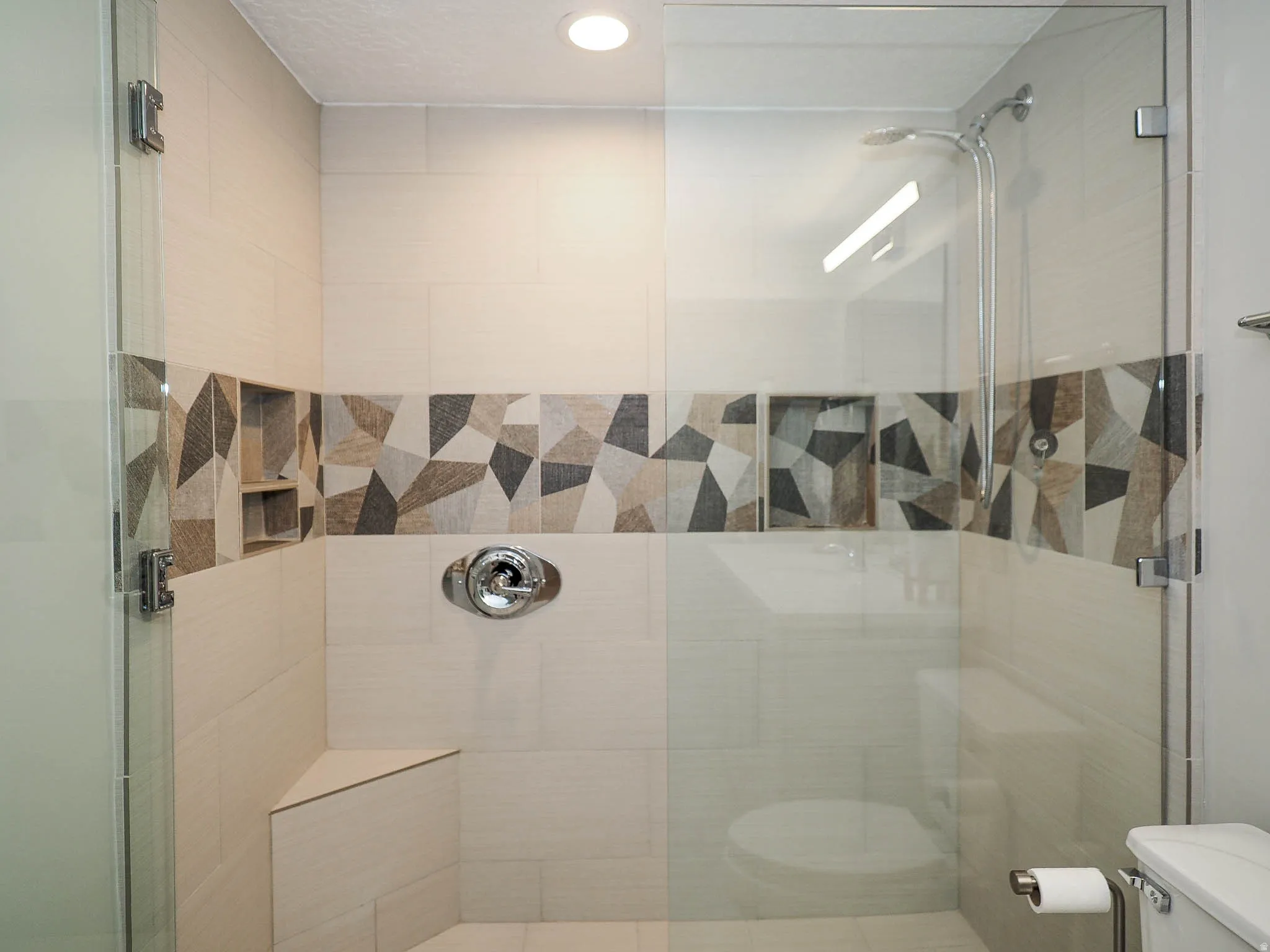 Beautifully Remodeled Walk-In Shower Featuring an Attractive Mosaic Accent Band, Exquisite Glass Enclosure, Convenient Built-In Bench, & More!