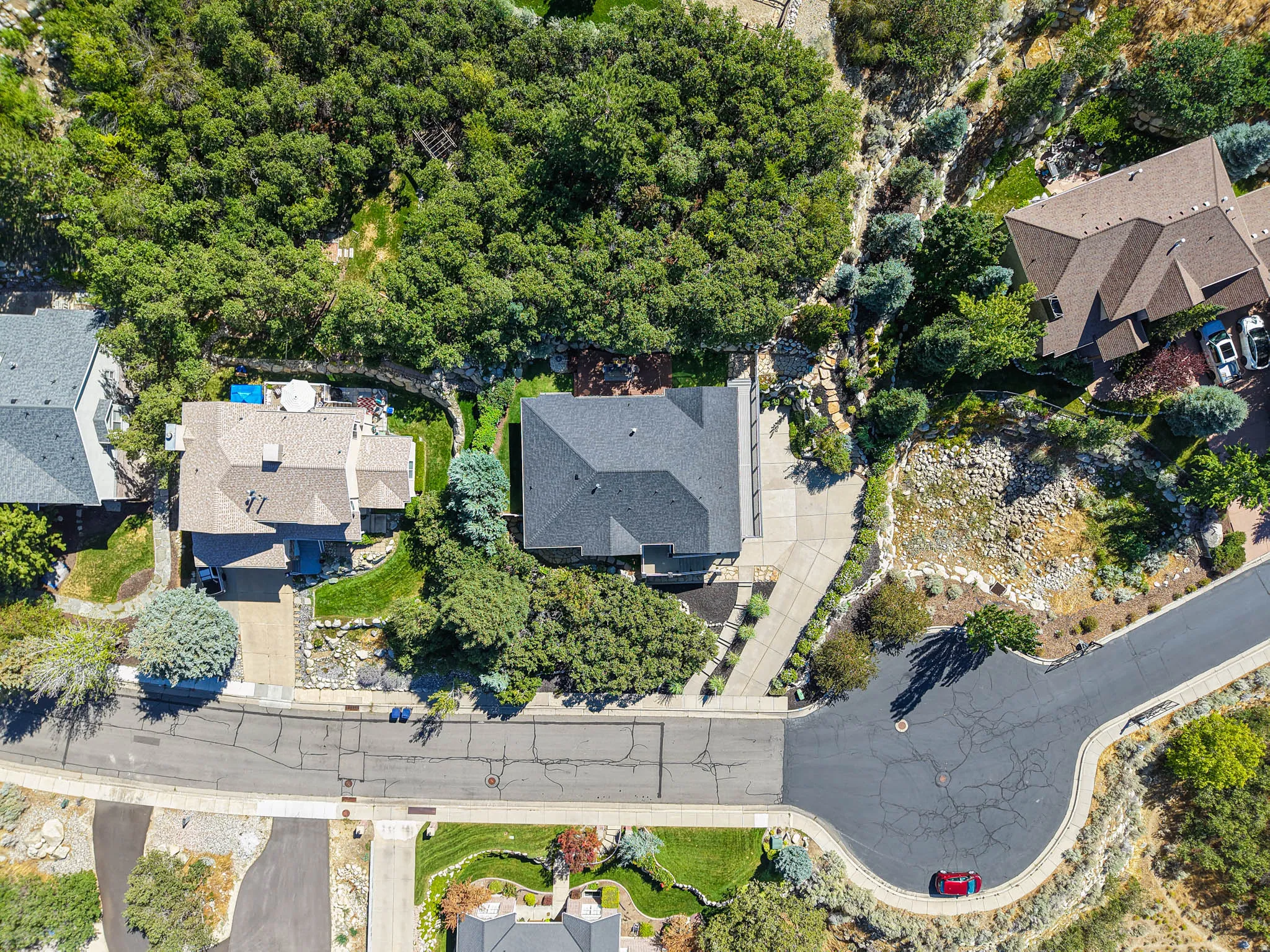 Beautiful low maintenance landscaping including natural rock, mature trees, a spacious driveway, plenty of parking, and on a cul-de-sac