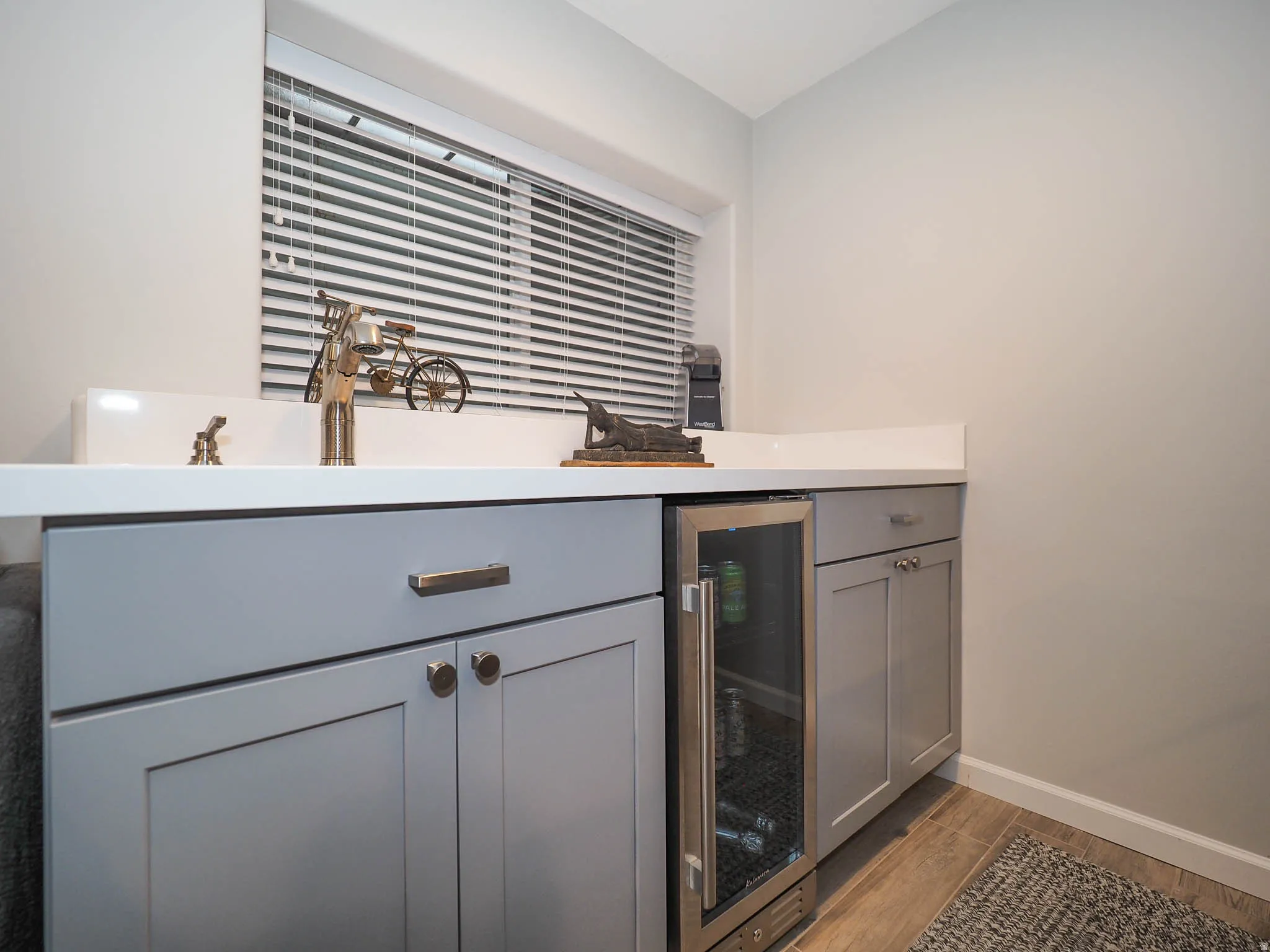 Awesome Family Room Wet Bar with Attractive Light Gray cabinetry, Lovely White Countertop, Mini-Refrigerator & More!
