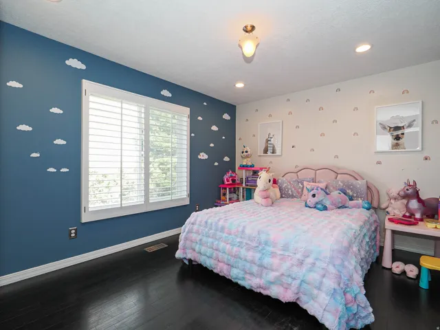 Spacious 3rd Bedroom  Featuring Beautiful Wood-Finish Flooring and a Large Window with White Plantation Shutters