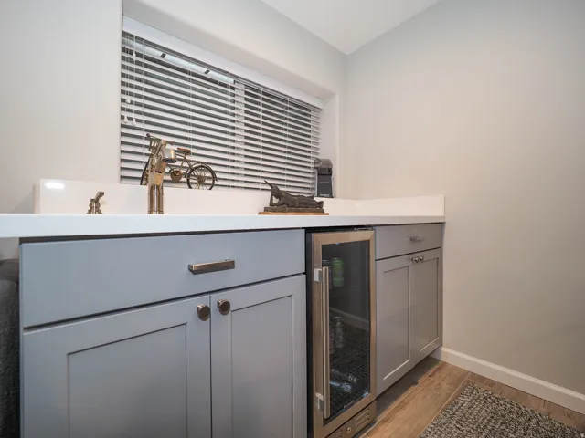 Awesome Family Room Wet Bar with Attractive Light Gray cabinetry, Lovely White Countertop, Mini-Refrigerator & More!