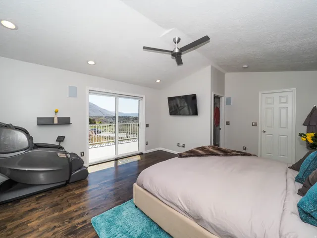 Large, Private Primary En Suite with Expansive Vaulted Ceiling, Modern Newer Ceiling Fan, Wonderful Newer Patio Door with Newer Remote Controlled Electronic Shade Offering a Seamless Connection to Romantic Outdoor Spaces from Your Beautiful Newer Deck!