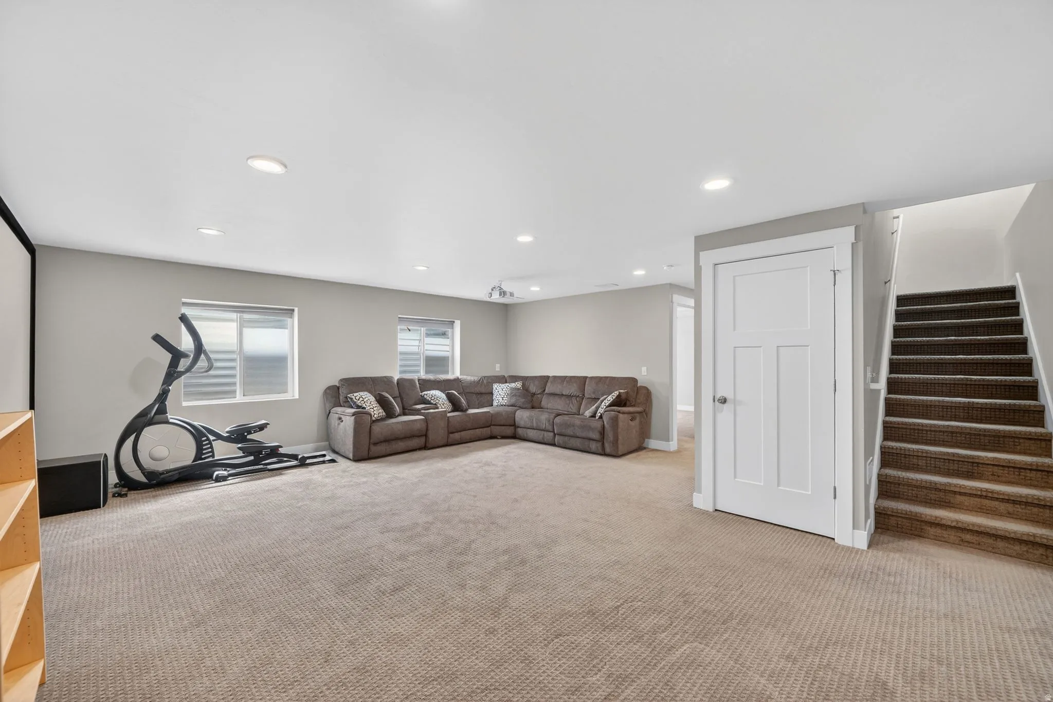 Spacious carpeted room featuring recessed lighting and multiple windows