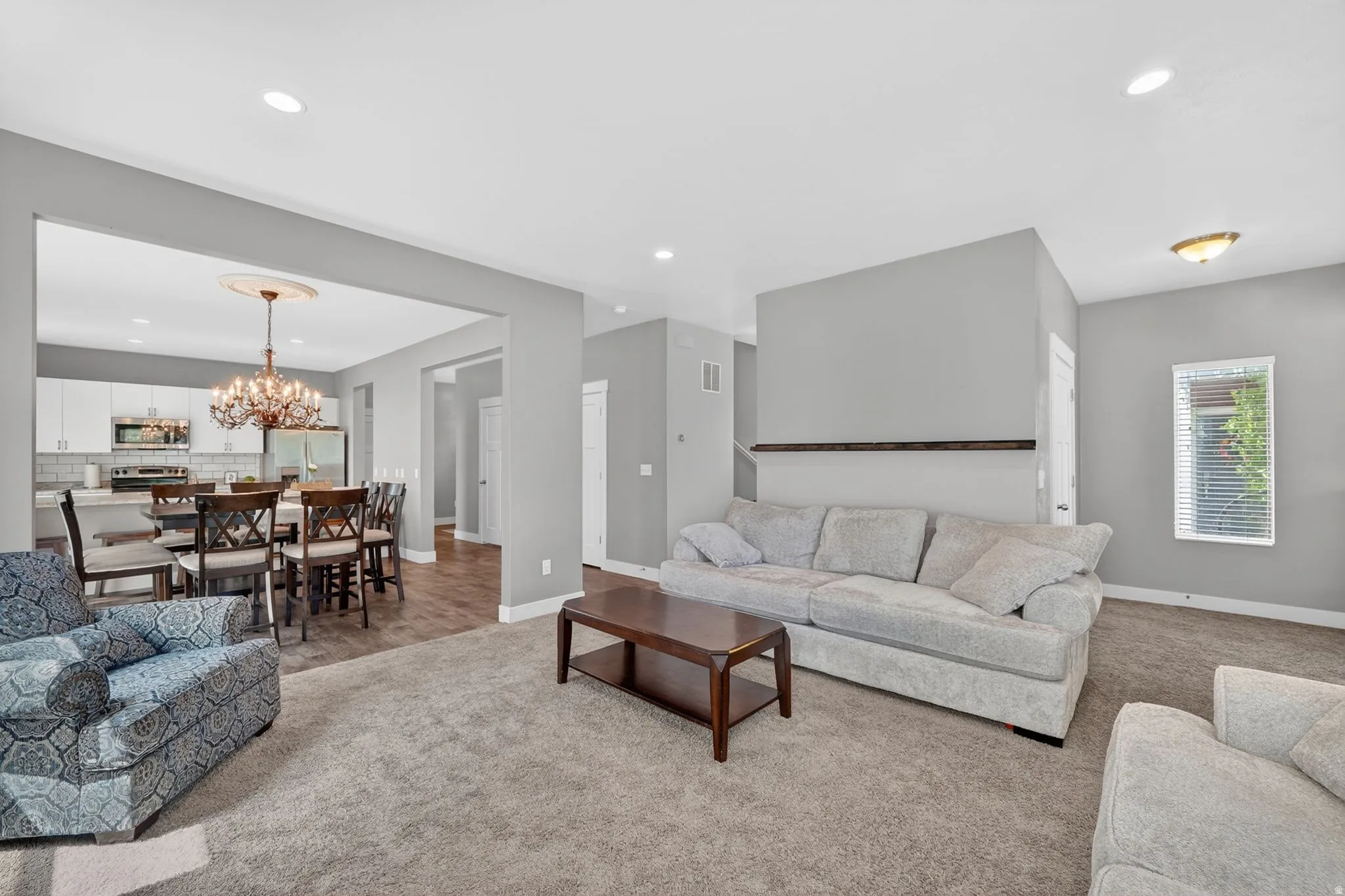 Spacious main living area featuring soft gray walls and recessed lighting