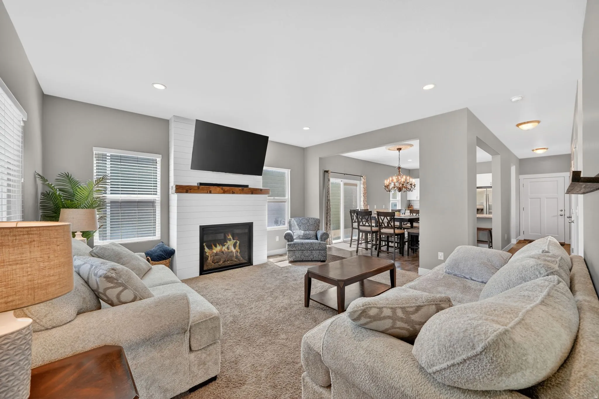 Living area featuring a modern fireplace with a white shiplap surround and a wood mantel