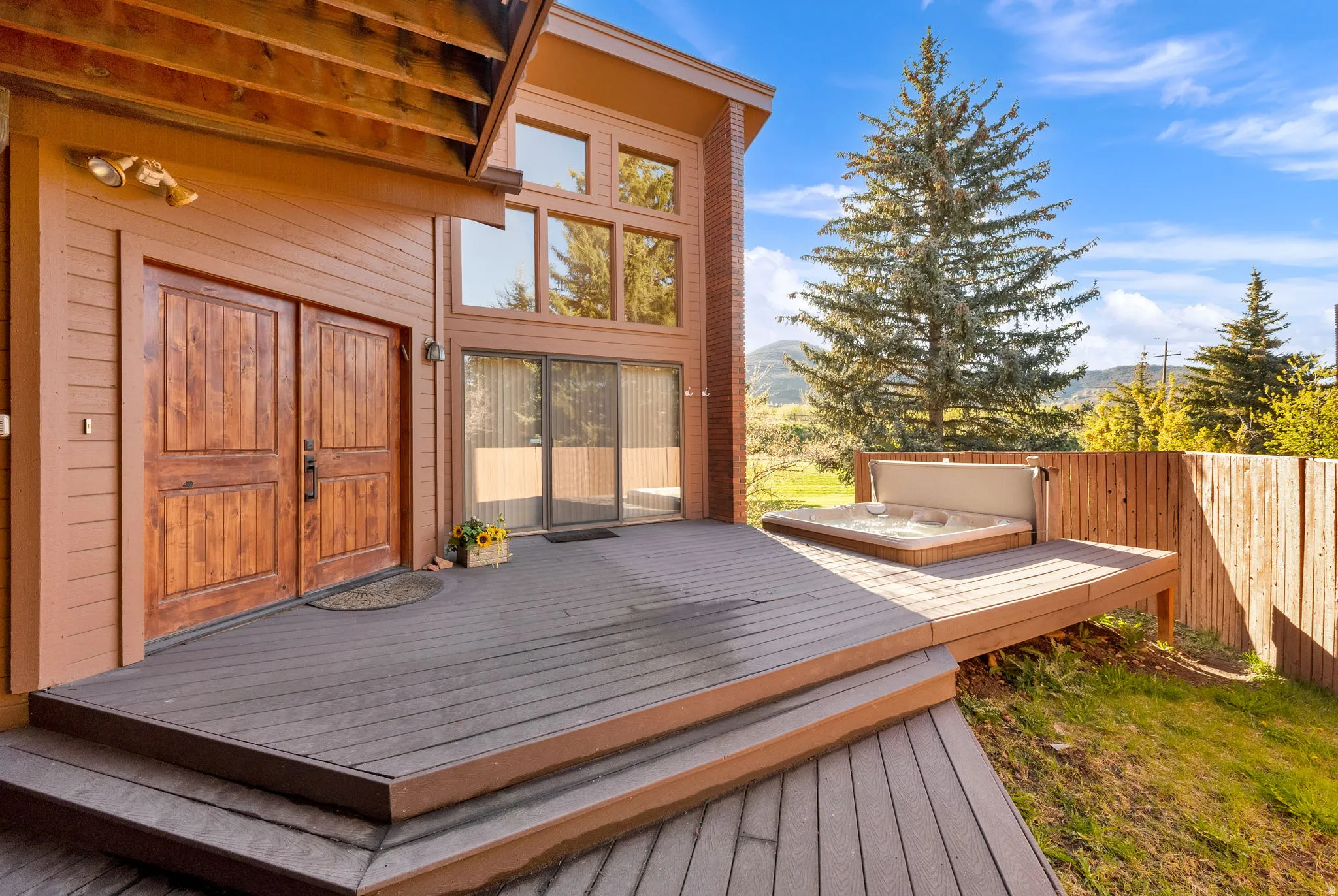 Expansive multi-level wood-finish deck with built-in spa