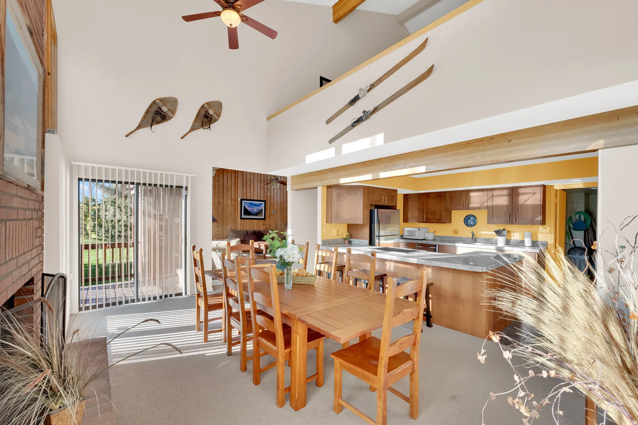 Spacious living area featuring a vaulted ceiling with exposed beams and a ceiling fan