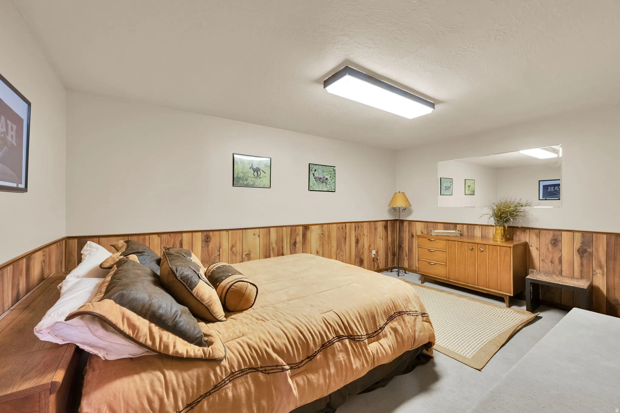 Room featuring wood-finish wainscoting, light-toned walls, and grey carpet flooring