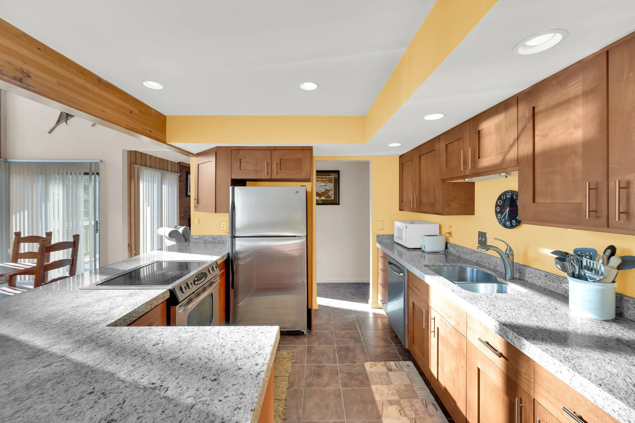 Kitchen featuring light wood-finish cabinetry, speckled countertops, stainless steel appliances, and recessed lighting