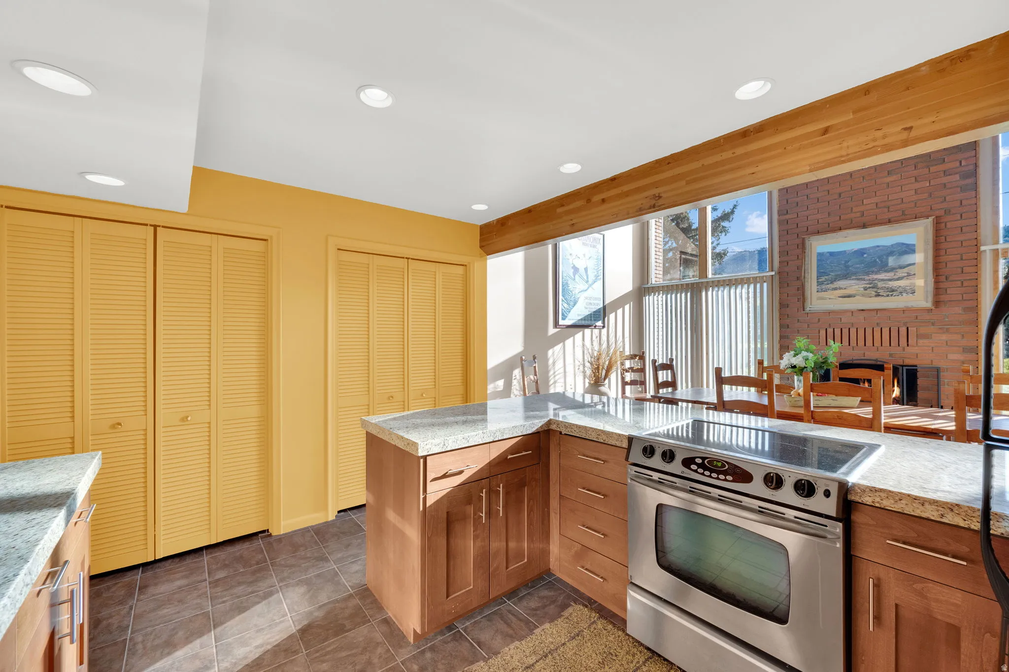 Kitchen featuring wood-finish cabinetry, light-toned countertops, and a stainless steel range