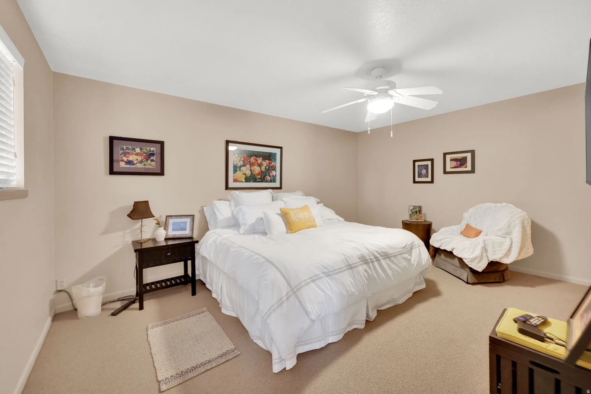 Plush carpet flooring, a ceiling fan with integrated lighting, and neutral wall tones define this inviting room