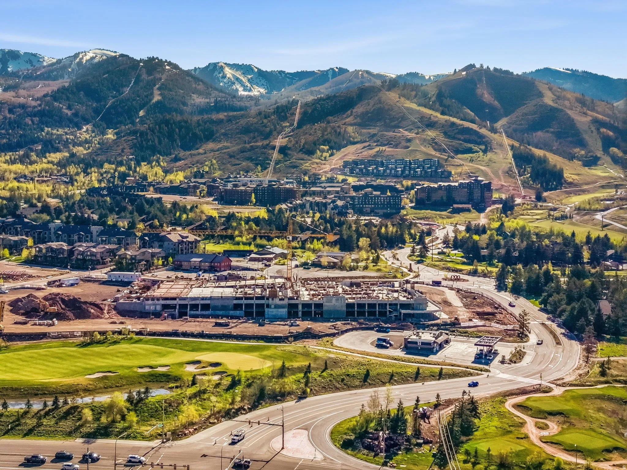 Developing community featuring a golf course, expansive roads, and a prominent commercial construction project