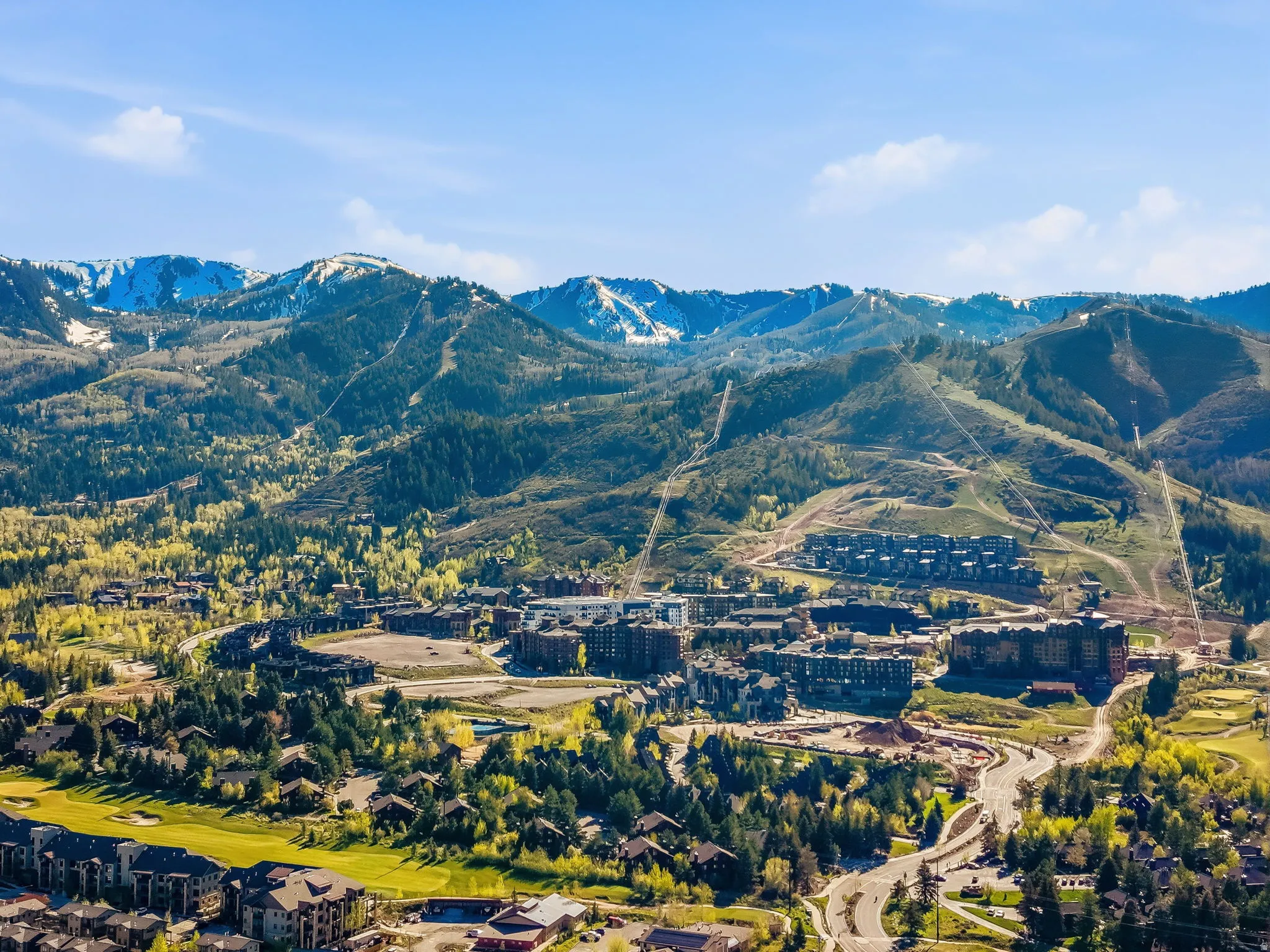 Expansive mountain landscape featuring snow-capped peaks and forested slopes
