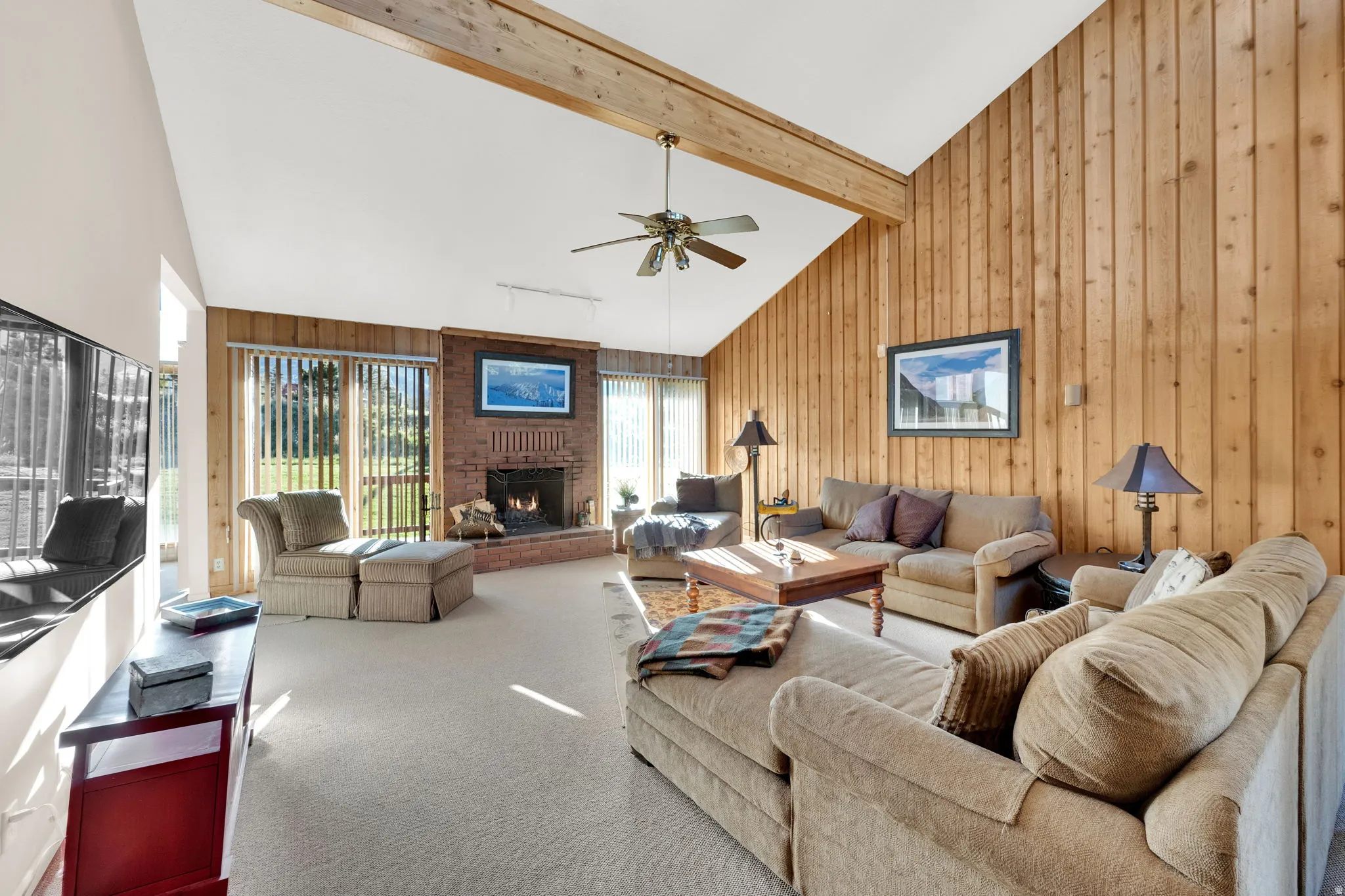 Vaulted ceiling with exposed wood beam and ceiling fan