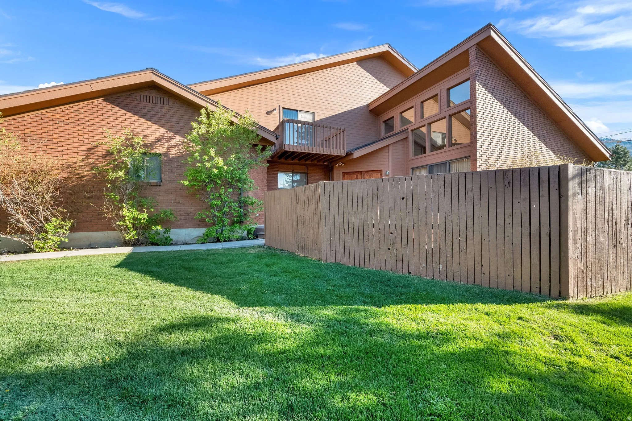 Expansive green lawn with a privacy fence