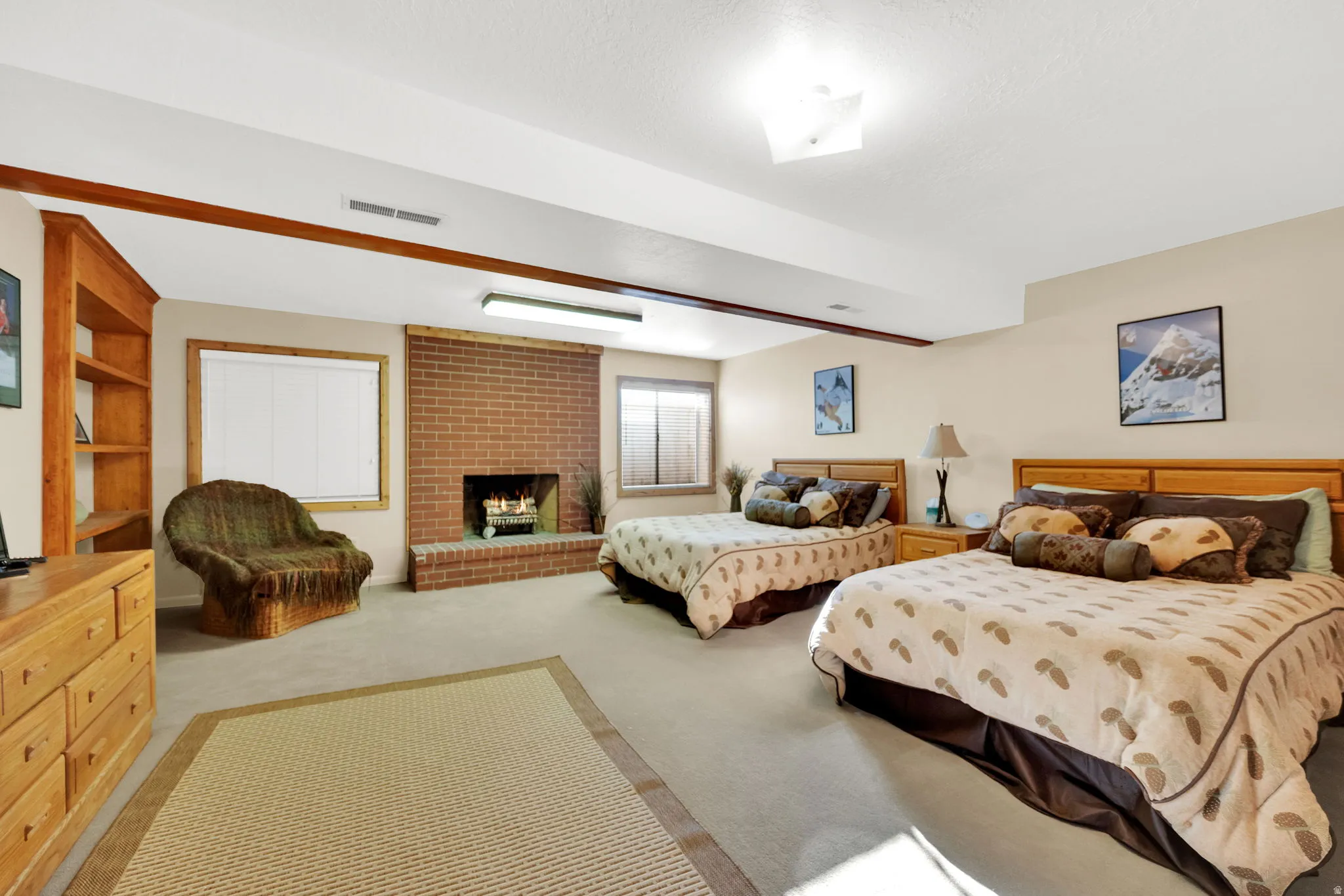 Spacious room featuring a brick fireplace, built-in wooden shelving, neutral-toned walls, recessed lighting, and carpet flooring