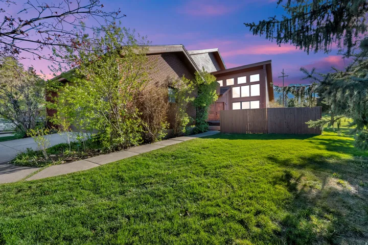 Angled architectural elements define this brick and wood-sided residence