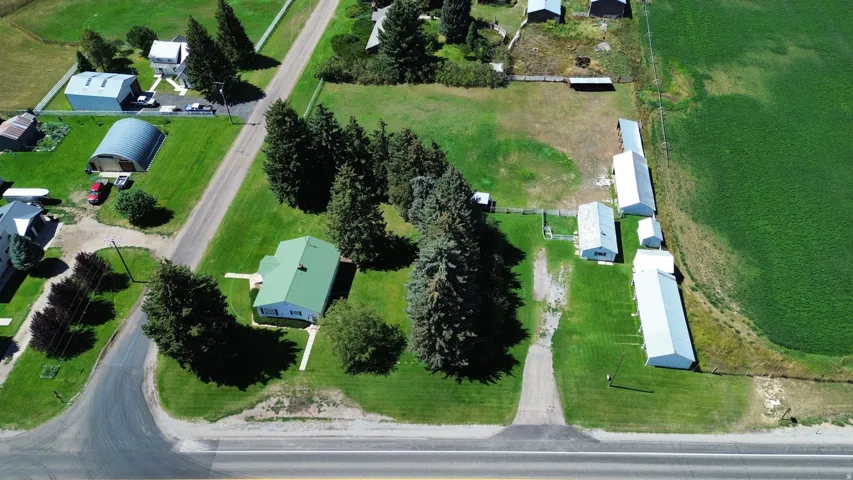 Expansive lot featuring a main residence, multiple outbuildings, and a surrounding open field