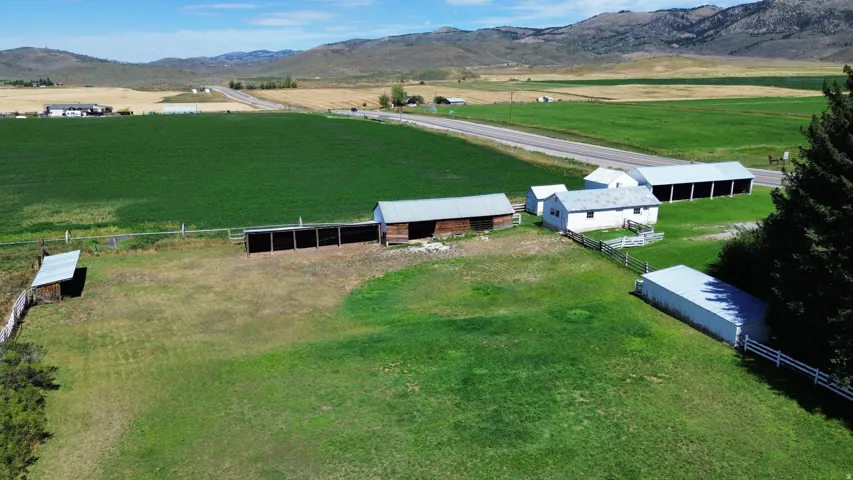 Expansive grounds featuring multiple outbuildings, fencing, and mature trees