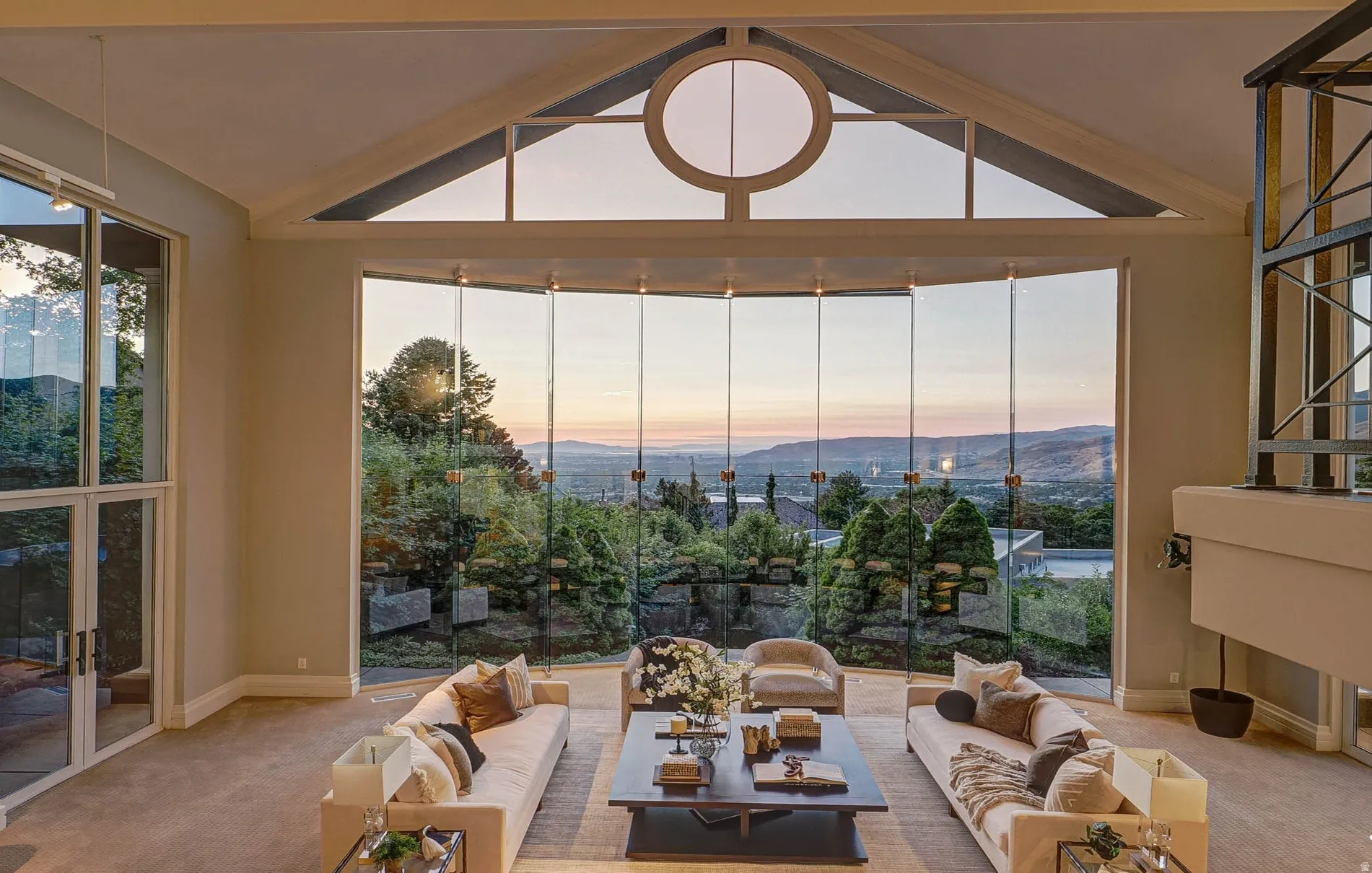 Expansive living area featuring a vaulted ceiling and floor-to-ceiling glass paneling