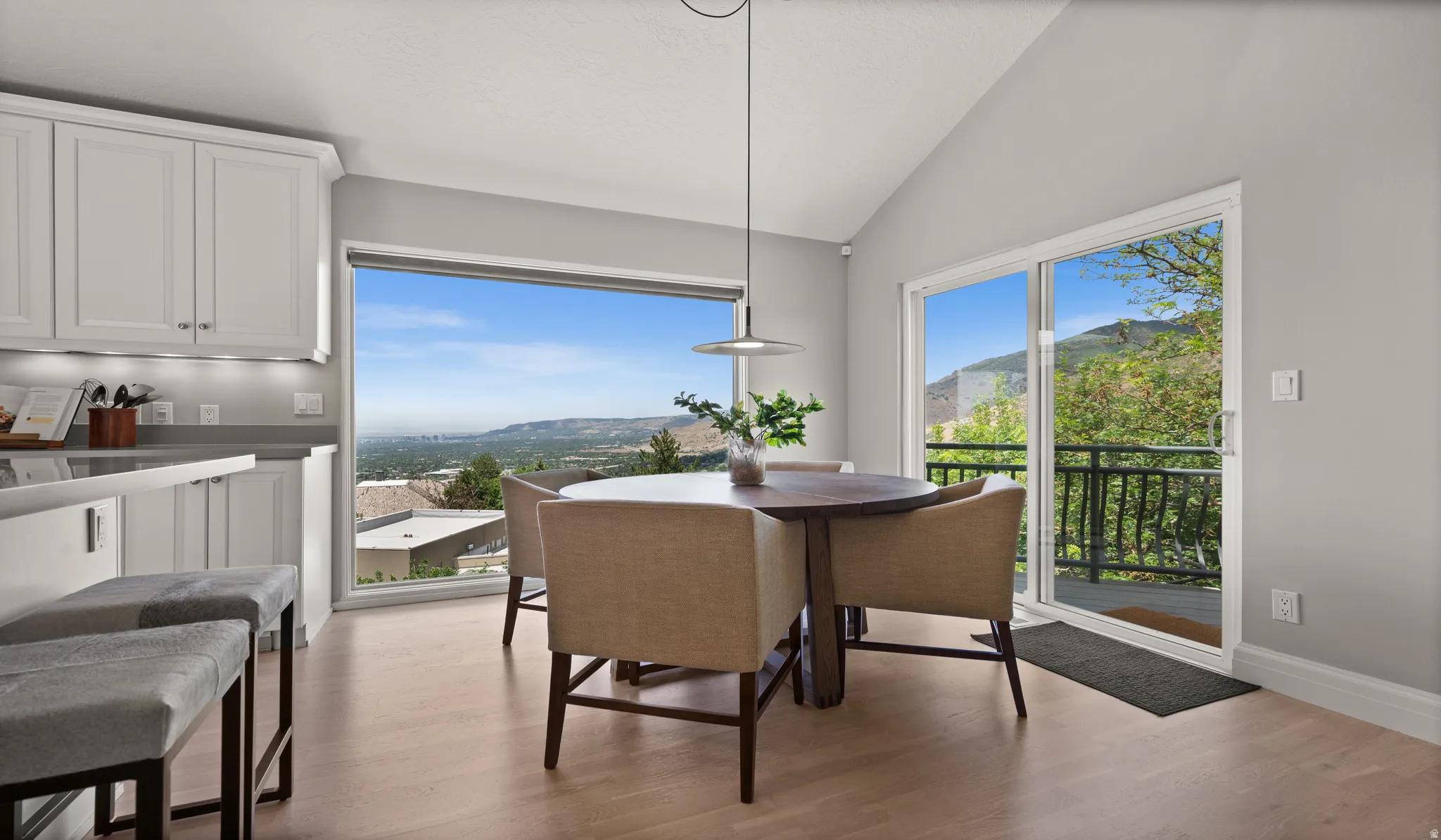Open-concept kitchen and dining area featuring a vaulted ceiling and wood-finish flooring