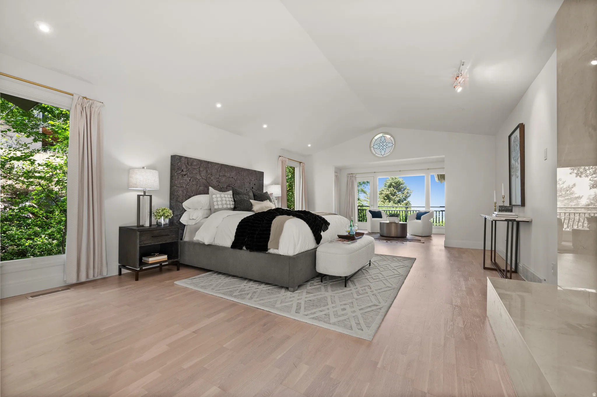 Spacious room with wood-finish flooring, vaulted ceilings, and recessed lighting