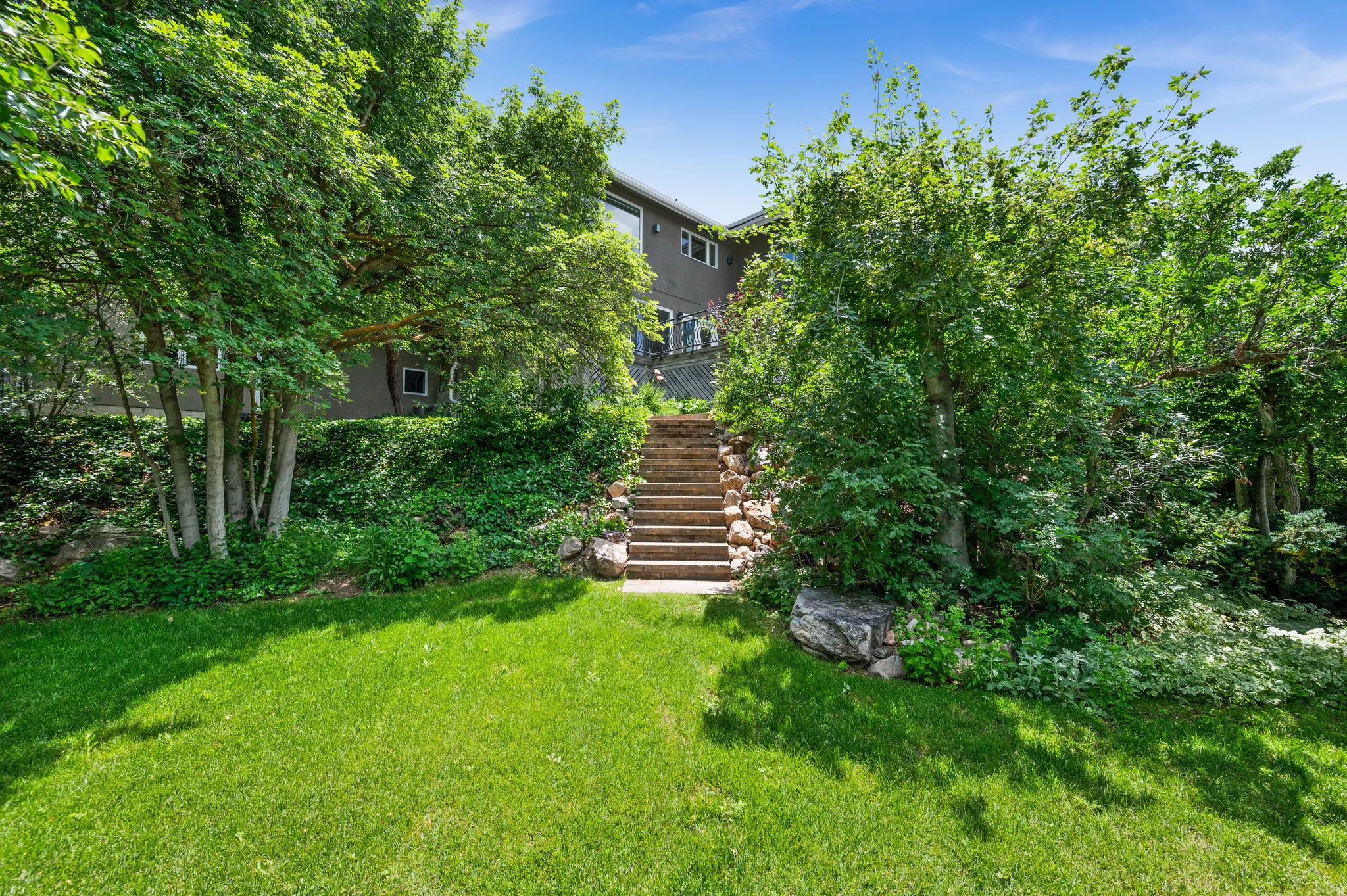 Expansive lawn featuring mature trees and lush landscaping