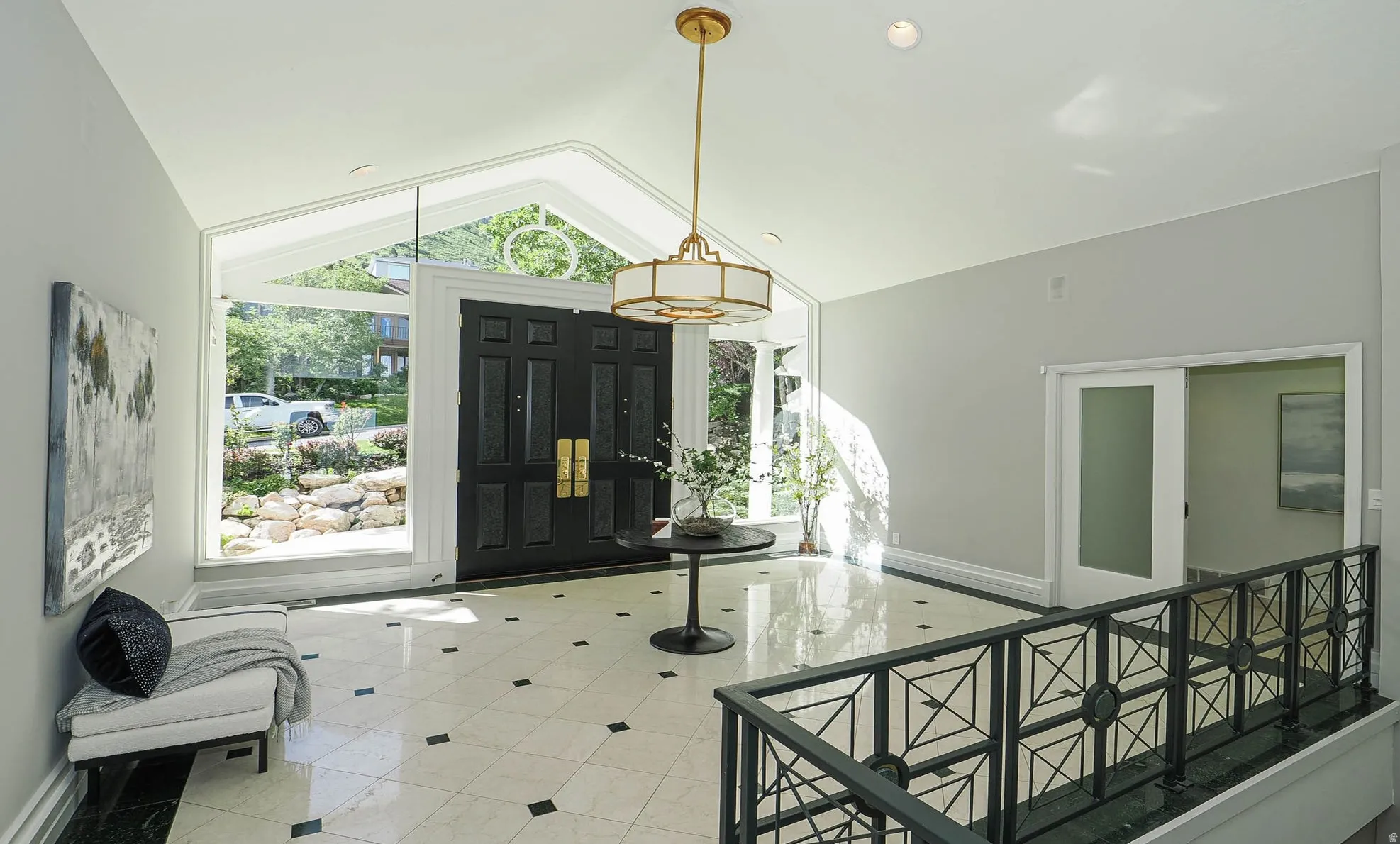 Grand entry featuring a vaulted ceiling and an ornate double-door entrance with transom window