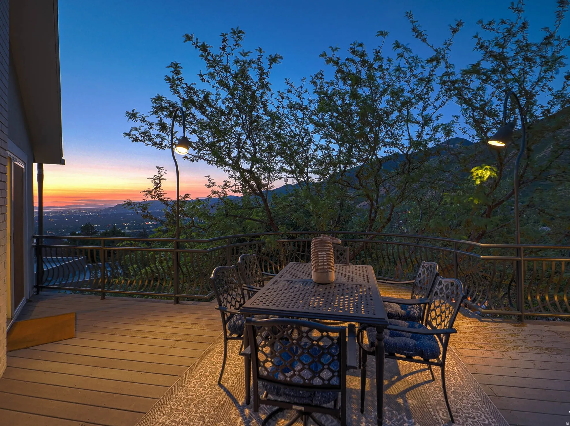 Spacious outdoor deck featuring wood-finish flooring and wrought iron railings