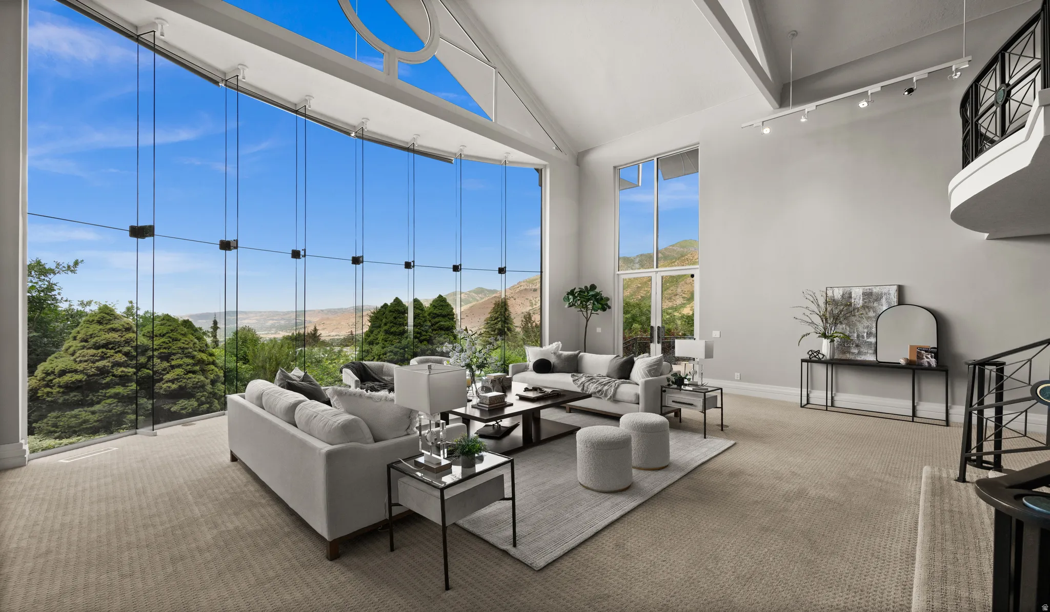 Two-story living area featuring a vaulted ceiling and an expansive window wall with integrated transom and arched windows
