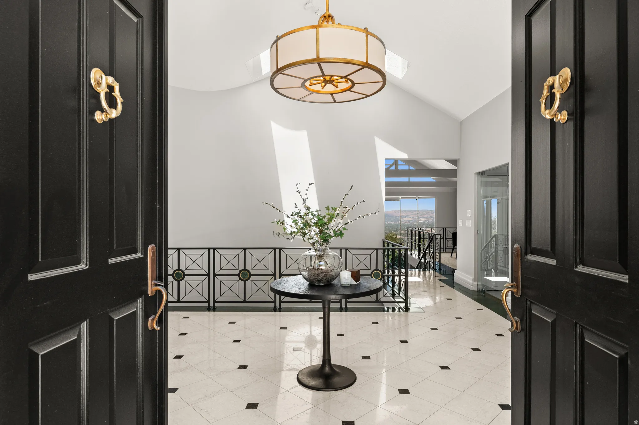 Grand entryway featuring double panel doors with brass hardware