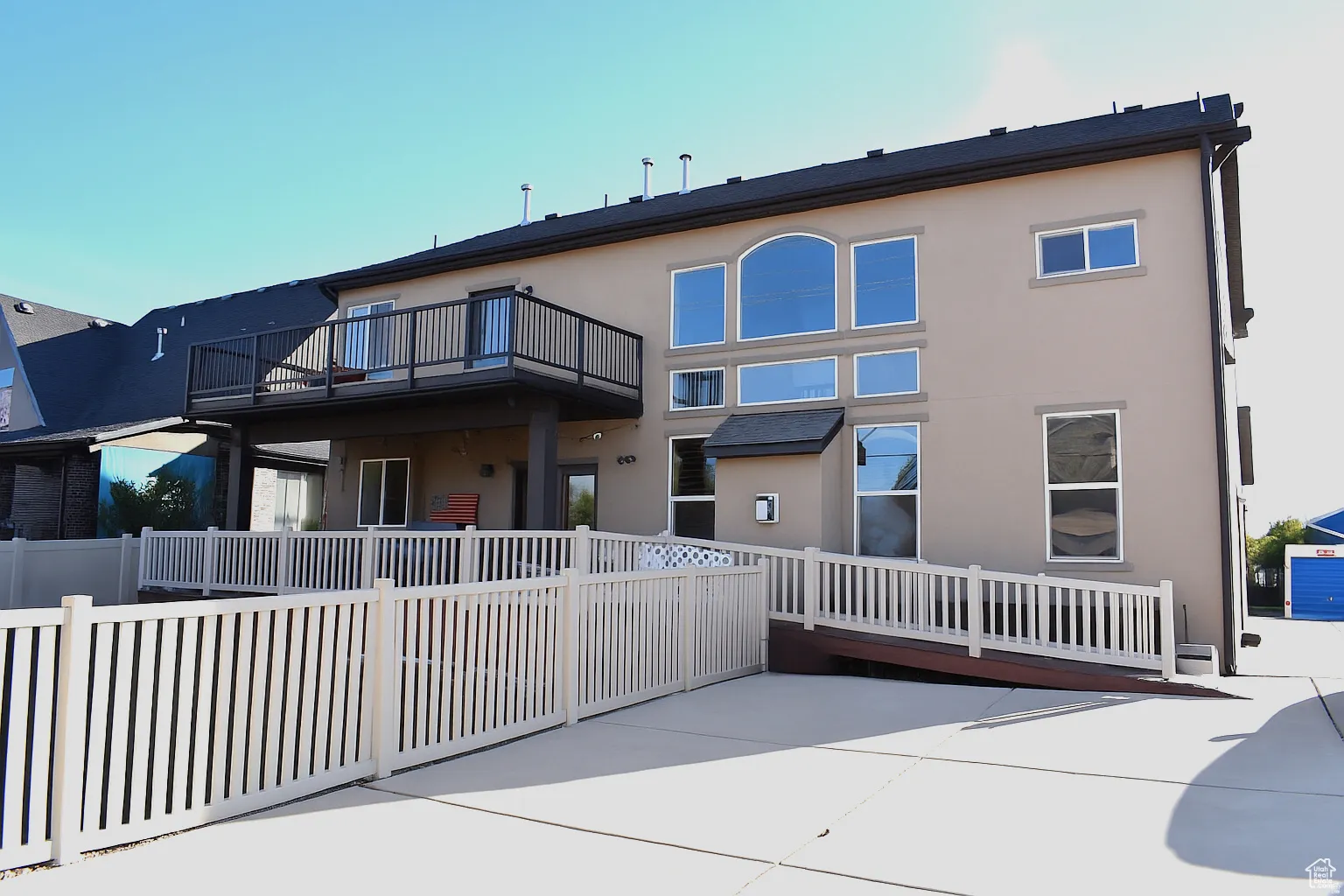 Rear view of house with accessible ramp and extra parking