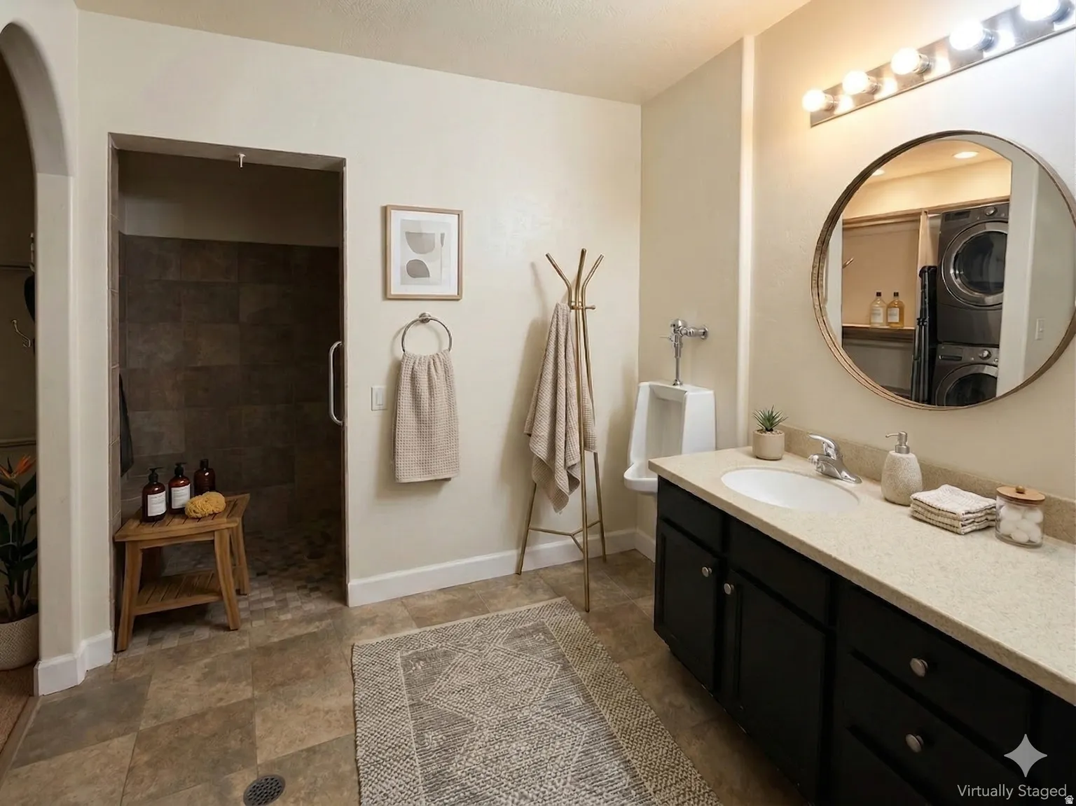 Full bath with vanity, stacked washer / dryer, and stone finish floors