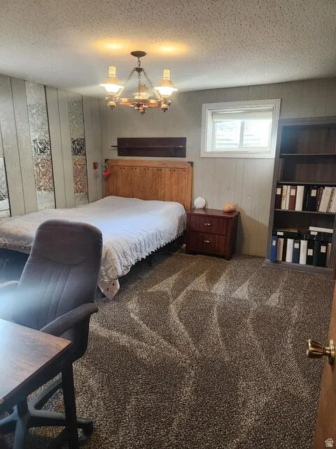 Textured wall paneling with an overhead chandelier and a built-in bookshelf