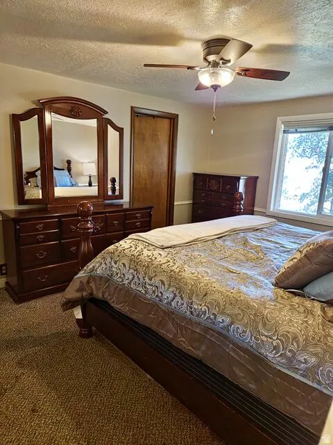 Bedroom featuring textured carpeting and a light-colored ceiling