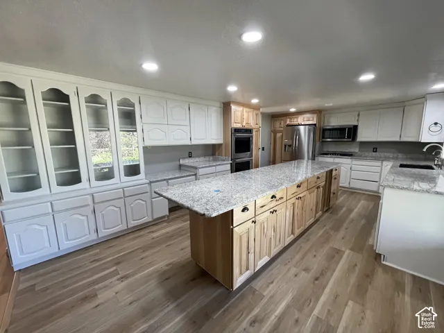 Spacious kitchen featuring a large central island with natural wood cabinetry and a light-toned countertop