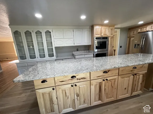 Spacious kitchen featuring a large island with light-toned wood cabinetry and ample countertop space