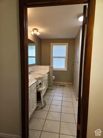 Bathroom featuring a dual vanity with white cabinetry, light-toned countertop, and dual sinks