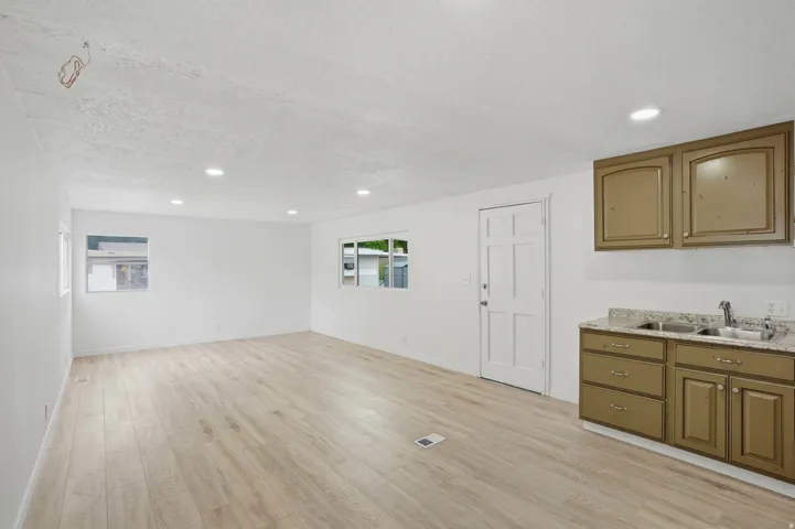 Light wood-finish flooring complements bright white walls and recessed ceiling lighting
