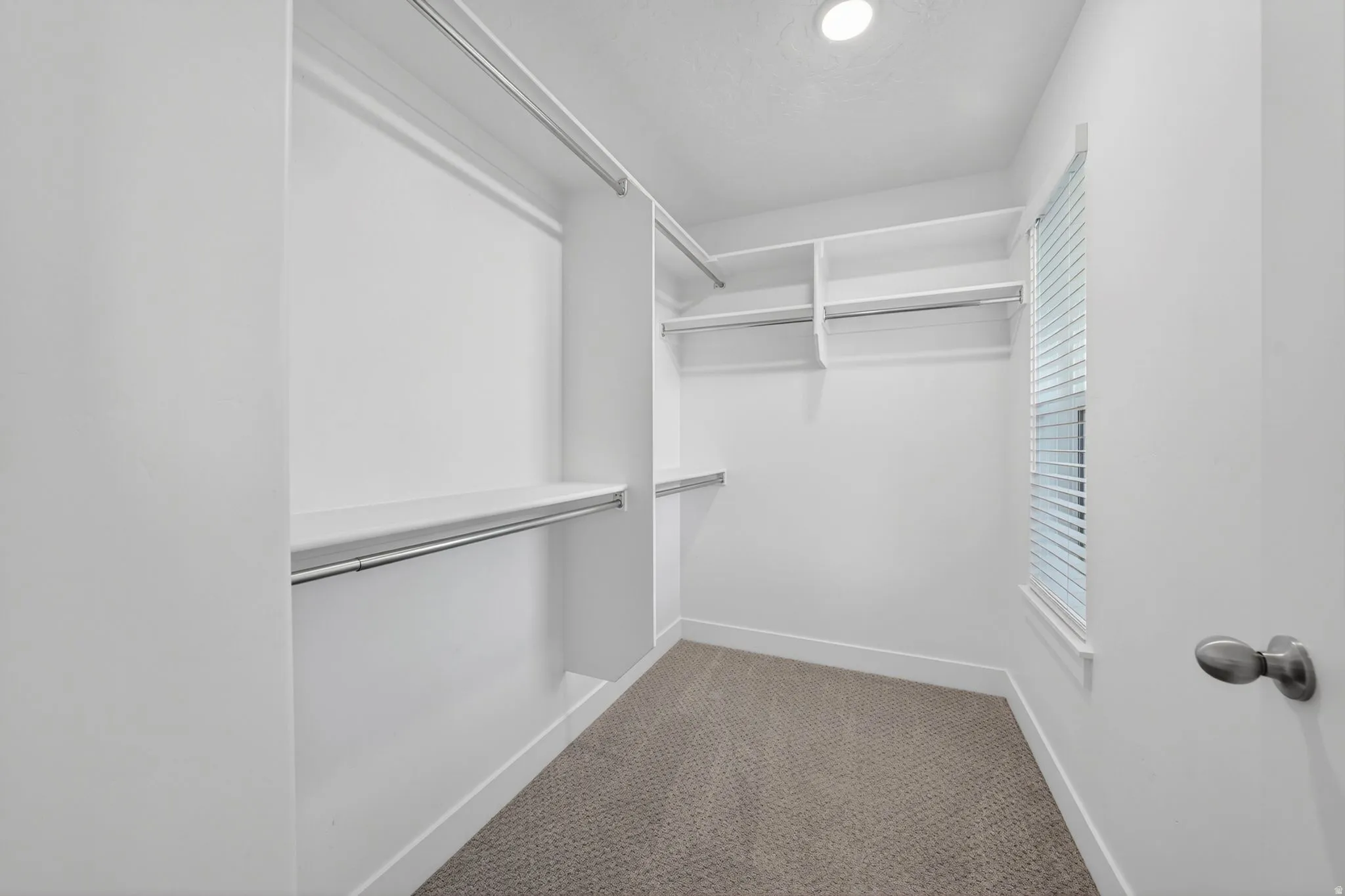 2nd Floor Primary Suite Walk-in closet featuring white built-in shelving,