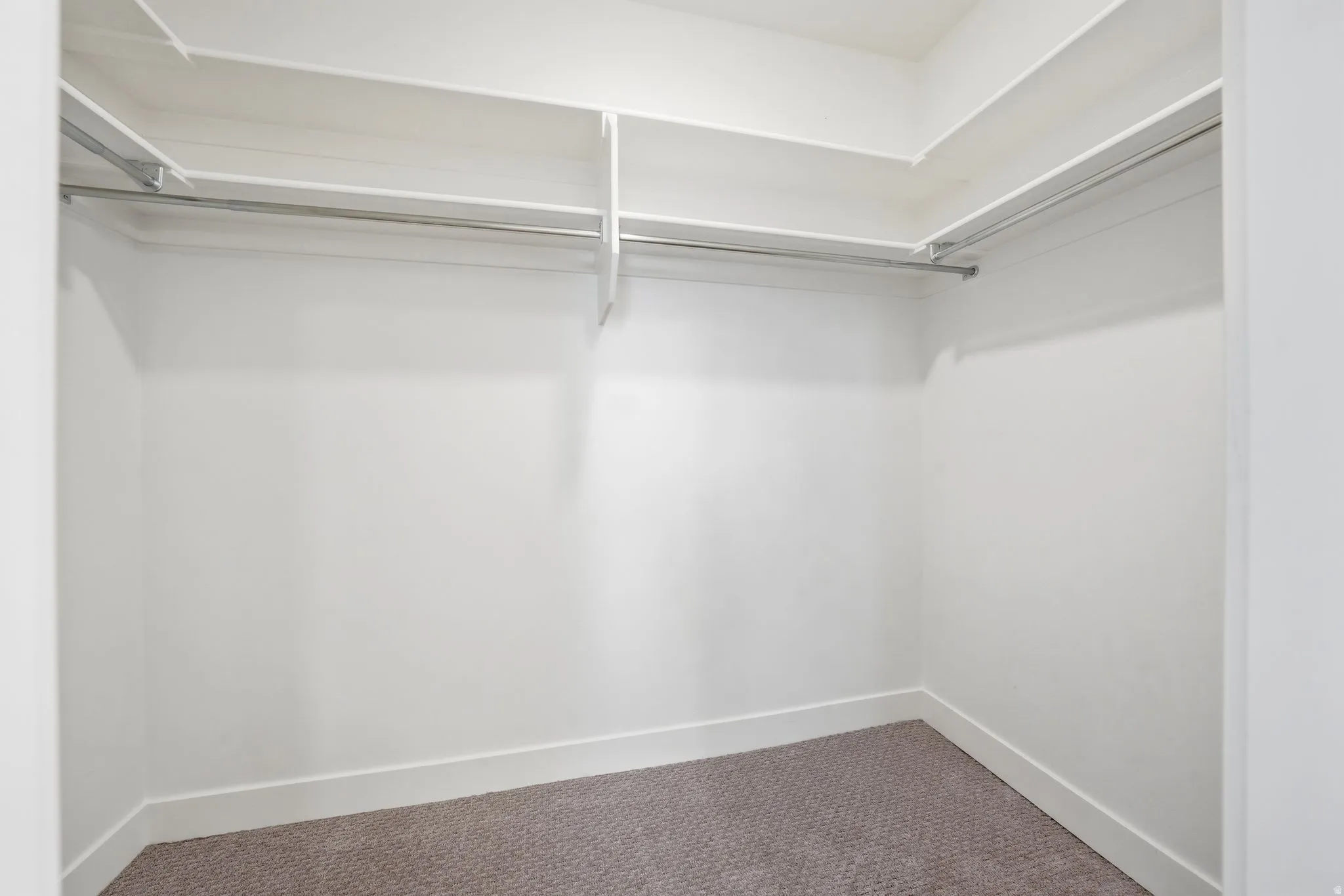 Spacious Primary Suite closet featuring white shelving