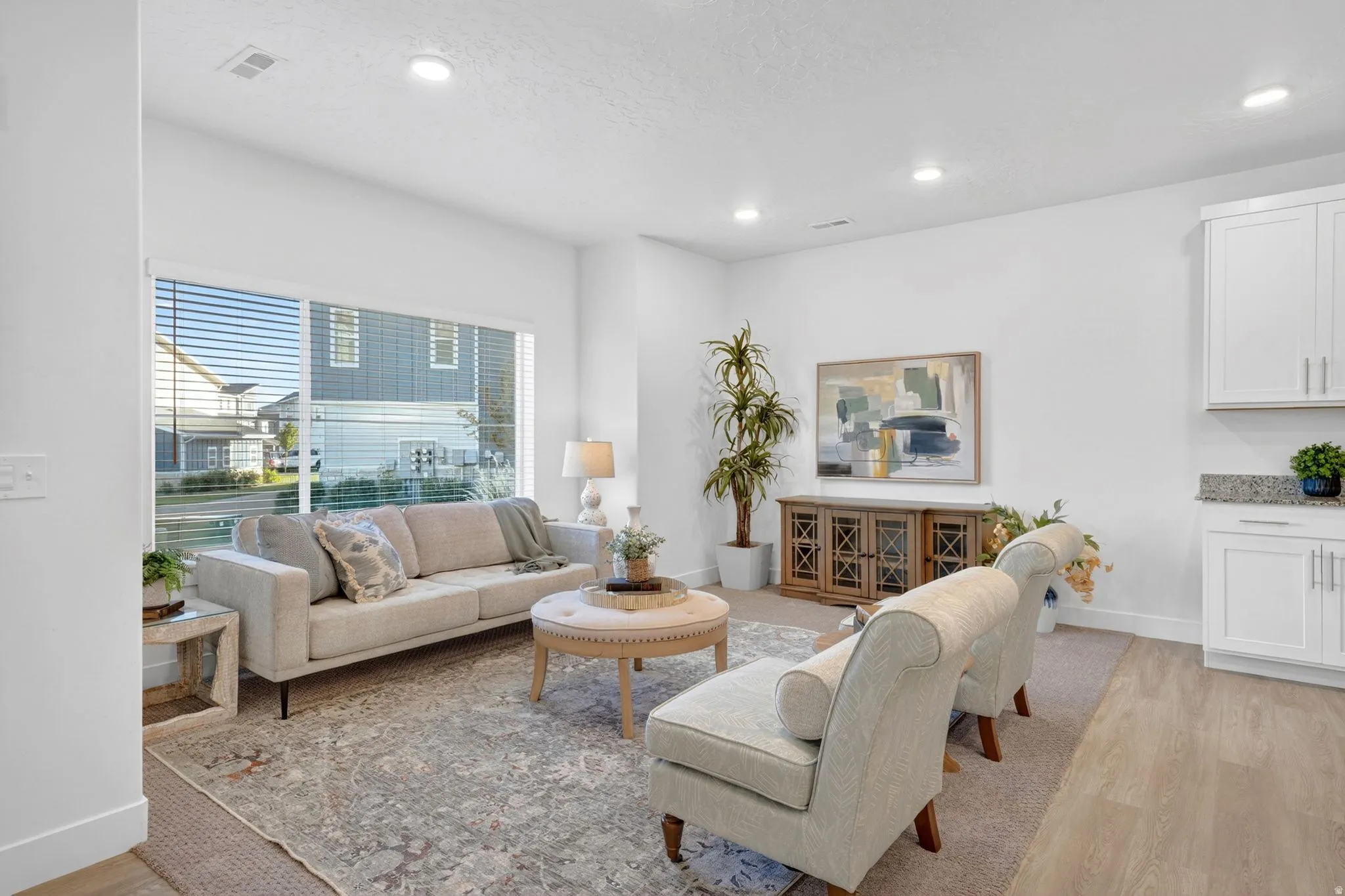 Spacious living area featuring a large windows, natural light and recessed lighting, and LVP  flooring