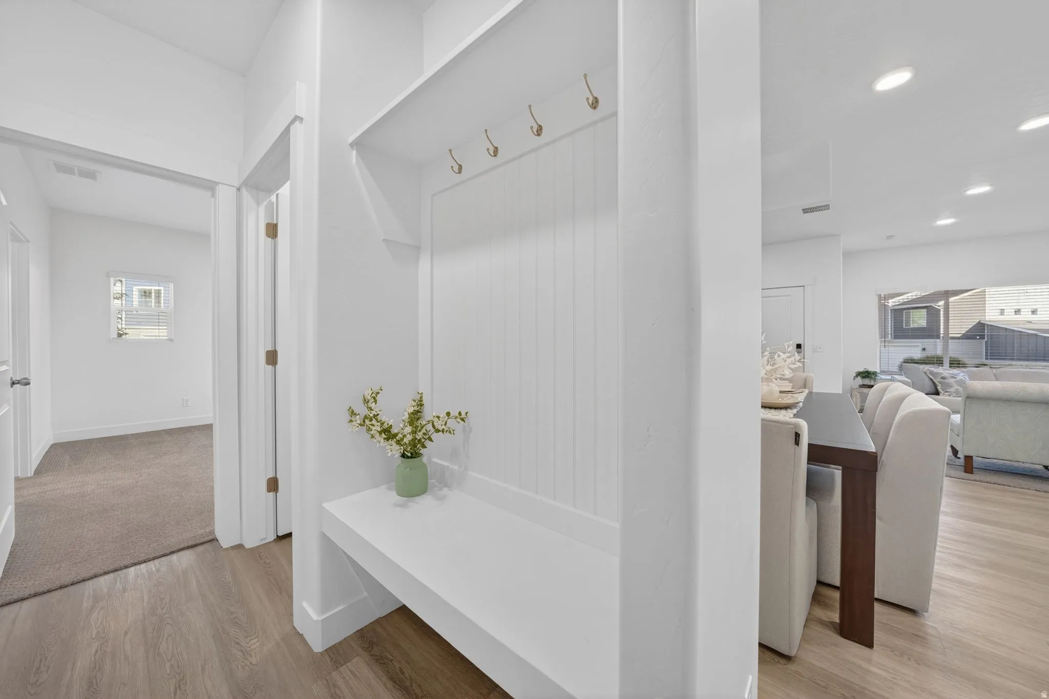 Built-in entryway bench with beadboard detailing and brass hooks