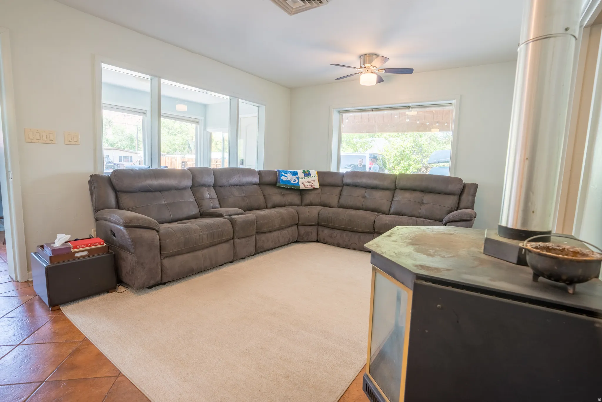 Tiled living room with a ceiling fan
