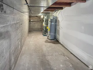 Concrete block foundation wall with exposed wood ceiling joists and unfinished concrete flooring