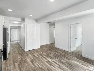 Contemporary interior featuring wood-finish flooring, recessed lighting, white trim, and white paneled doors