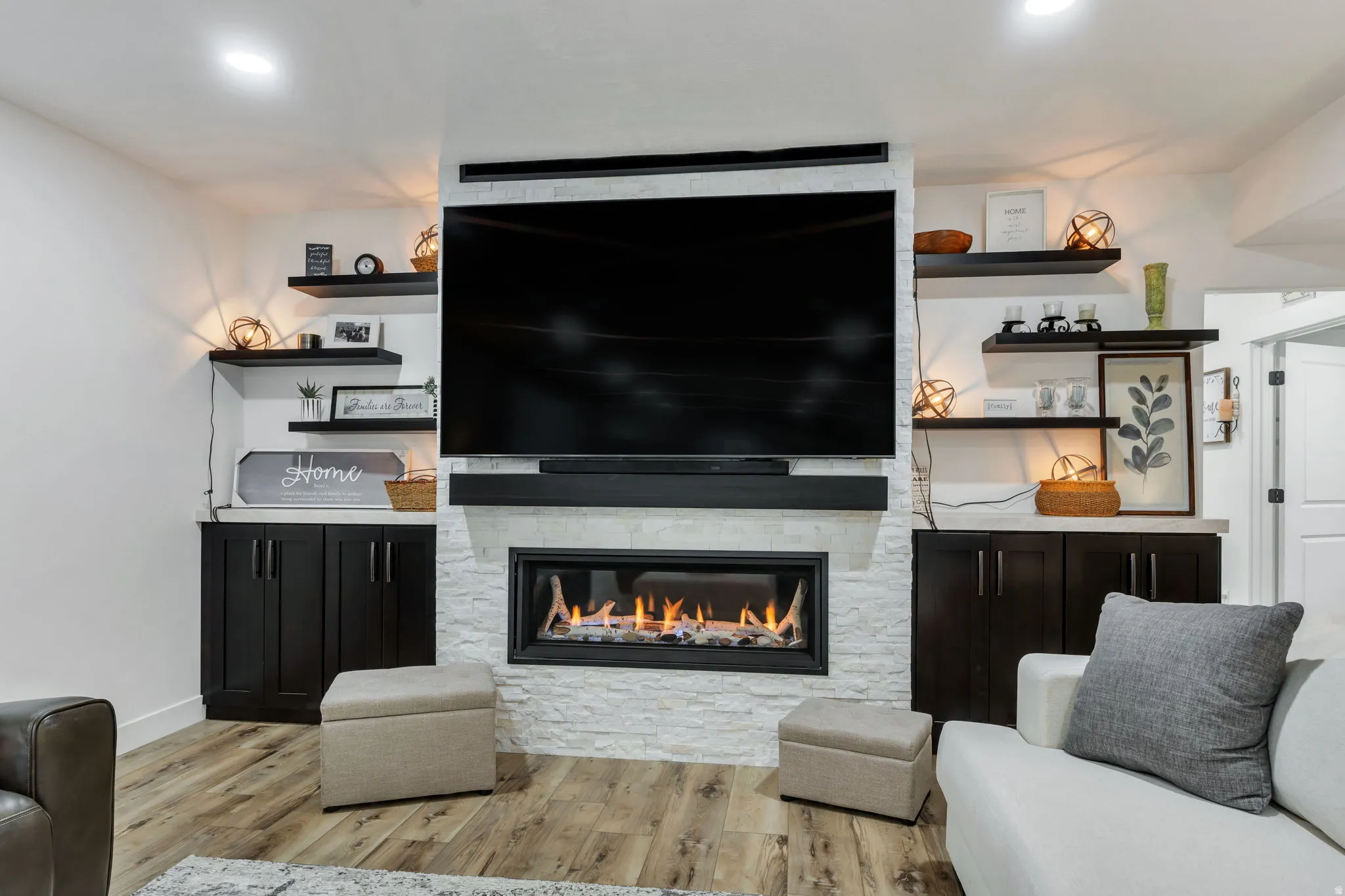 Integrated media wall with a built-in fireplace, surrounded by white stacked stone