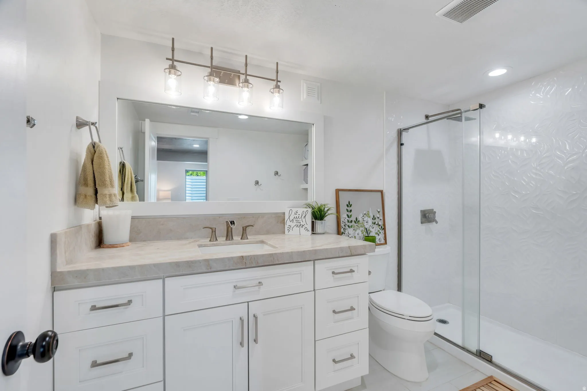 Contemporary bathroom featuring a spacious vanity with an undermount sink, a large mirror, and an overhead light bar